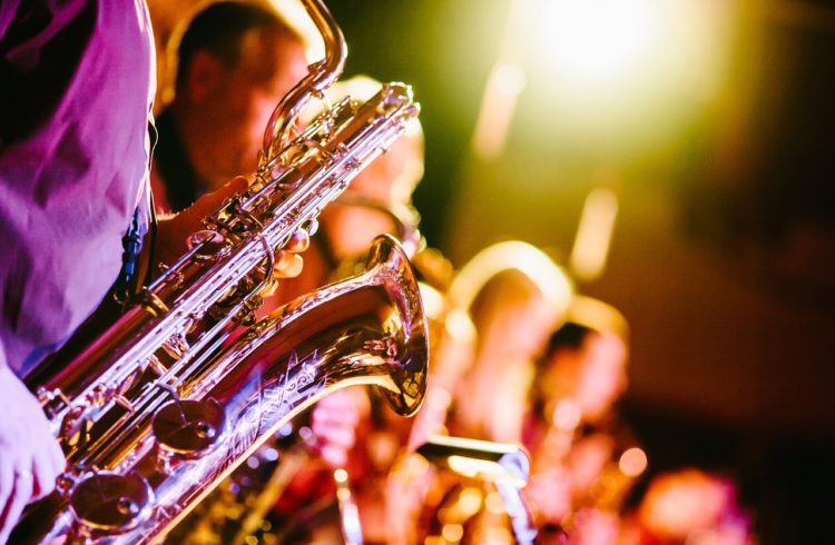 photo of a band with a party-like atmosphere with a saxophone up front in focus