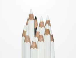 twelve pencils, all white except for one black